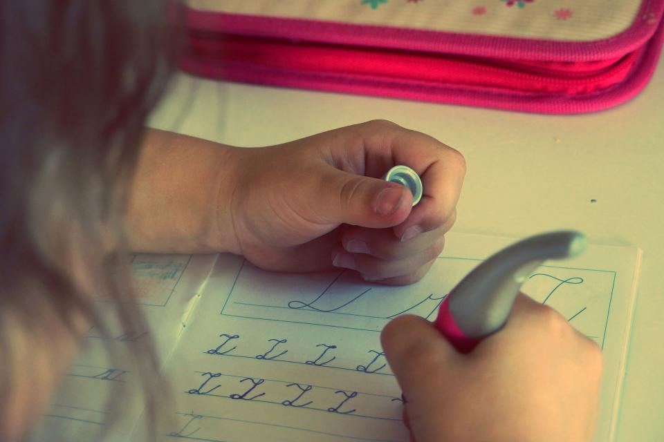Enfant s'exerçant à l'écriture cursive